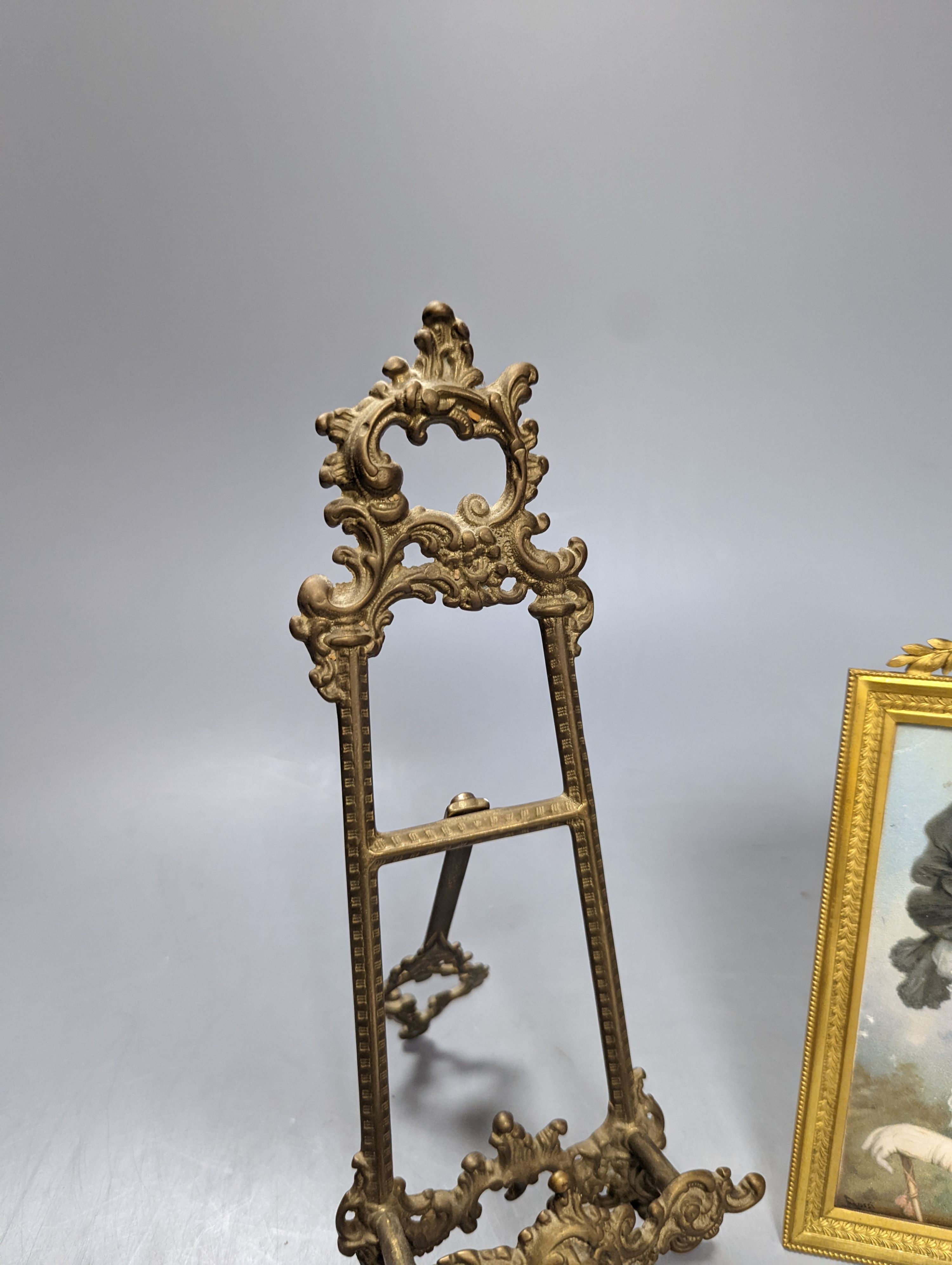 Victorian miniature print of a lady in a black feather hat in a gilt brass frame and a small brass easel, easel 25 cms high.